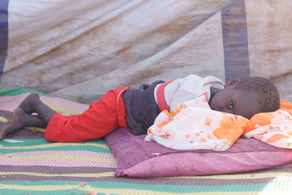 Un jeune garçon qui a fui El Fasher avec sa famille se repose dans un camp pour personnes déplacées.