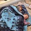طفلان ينامان في العراء في منطقة المواصي، جنوب قطاع غزة.