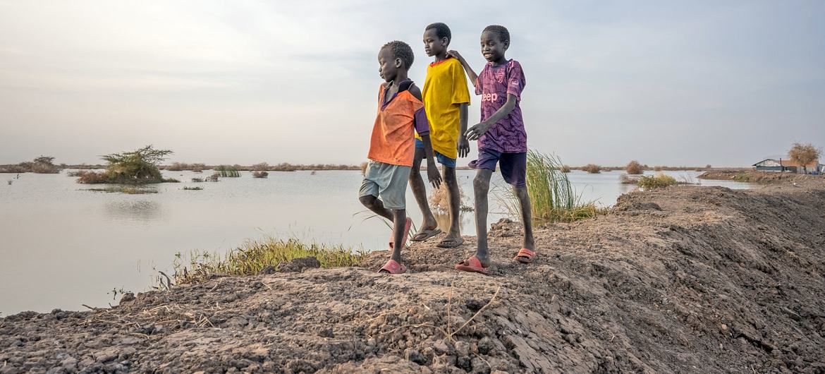 Boys walk past flooded fields in Bentiu, Unity state, South Sudan.