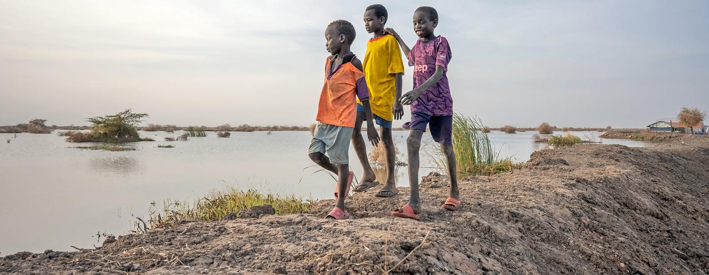 Des enfants marchent à côté de champs inondés à Bentiu, dans l’État d’Unity, au Soudan du Sud.