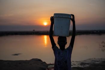 A girl carries water to her home at a camp for forcibly displaced people  in Bentiu, South Sudan.