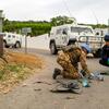 A UNIFIL forensic investigator and an Italian Carabinier examine drone remnants on the ground near a road in Naqoura.