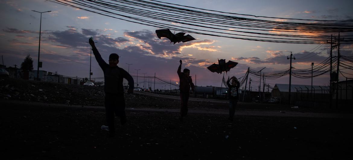 En Iraq, unos niños corren con cometas en el campo de Domiz, en Dohuk.