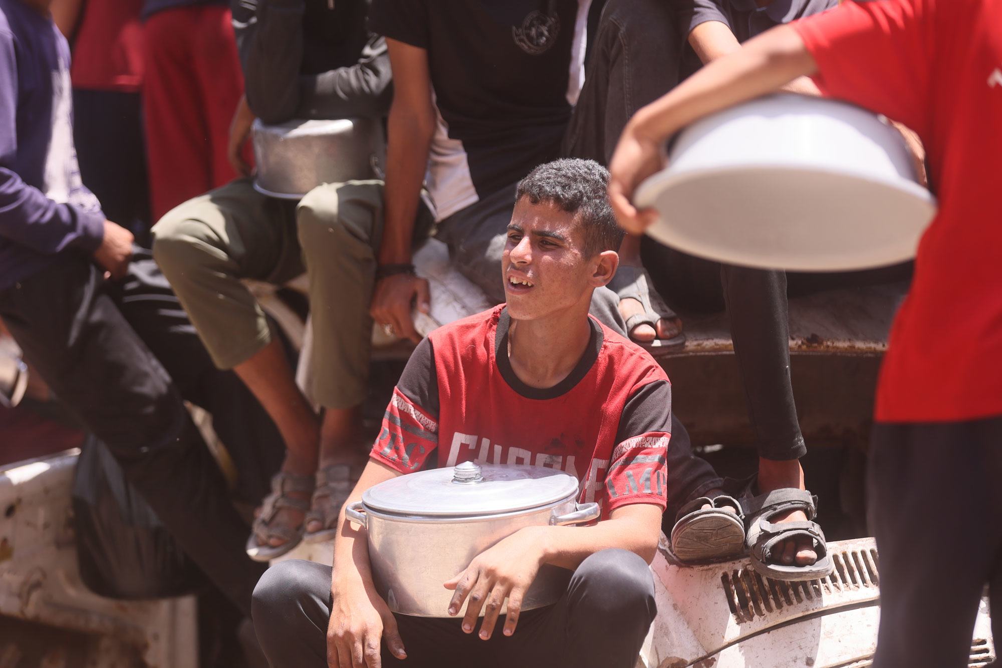 Un enfant attend de recevoir de la nourriture à Gaza.