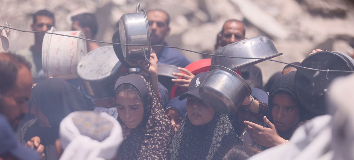 People in Gaza wait for food at a communal kitchen.