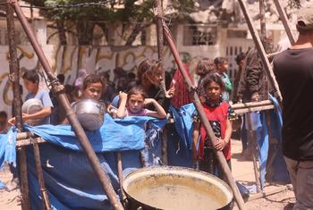 Children queue for food in Gaza.