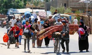 Las familias trasladan sus pertenencias mientras evacuan Deir Al-Balah, en la Franja de Gaza.