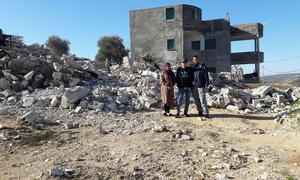 Palestinian refugees stand next to their demolished home in Jenin, West Bank. (file)