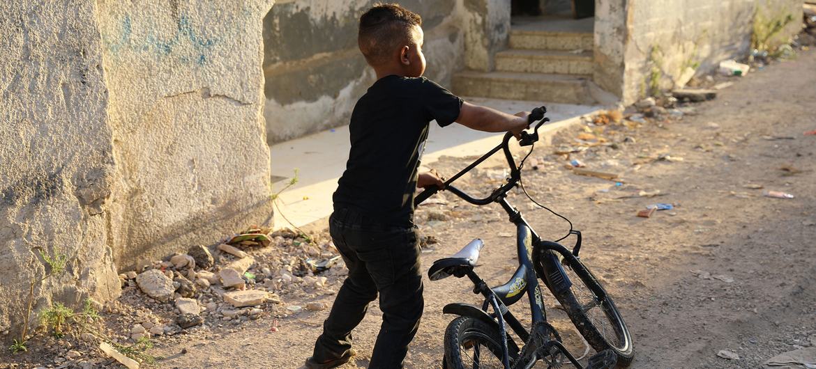 A child plays in front of his destroyed home in the Jenin refugee camp, West Bank. 