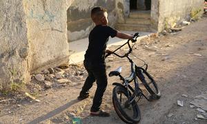 A child plays in front of his destroyed home in the Jenin refugee camp, West Bank. 