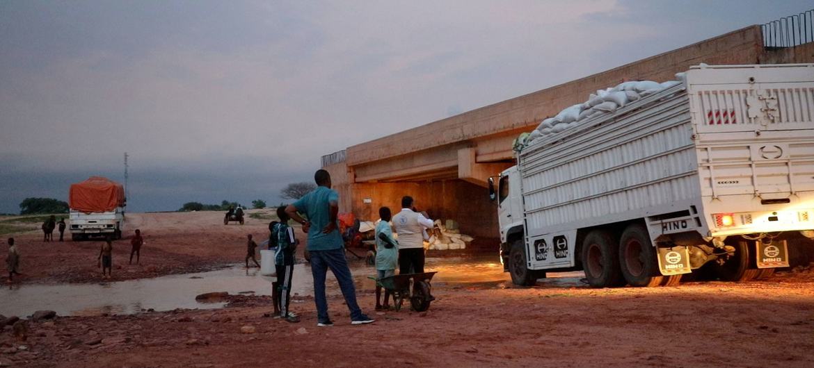 Caminhões que transportam suprimentos vitais de alimentos cruzam a fronteira do Chade para o Sudão via Adre