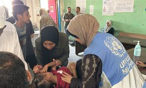 Una trabajadora de salud de la UNRWA examina a un niño con desnutrición en la ciudad de Gaza.