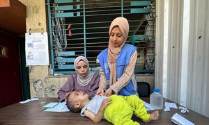 Un niño pequeño es evaluado por desnutrición por una trabajadora de la UNRWA en la ciudad de Gaza.