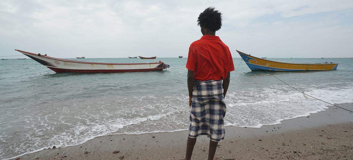 Een jonge migrant kijkt uit om te zien nadat hij vanuit Djibouti in Jemen is aangekomen.
