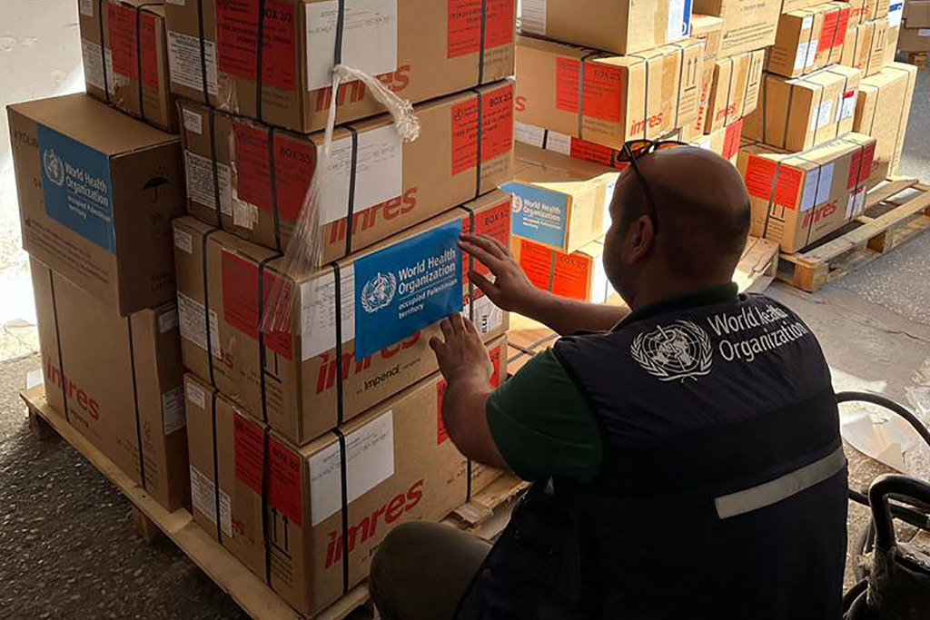 A WHO worker in Gaza prepares essential medical supplies for distribution.