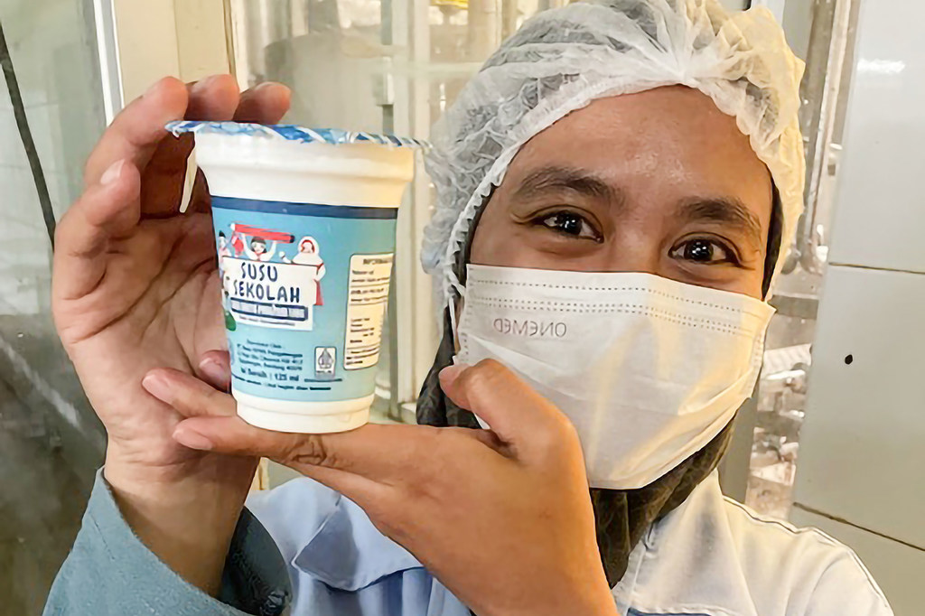A worker at the KPBS cooperative holds up a dairy product.