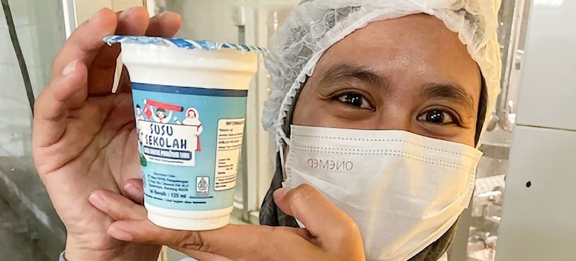 A worker at the KPBS cooperative holds up a dairy product.  