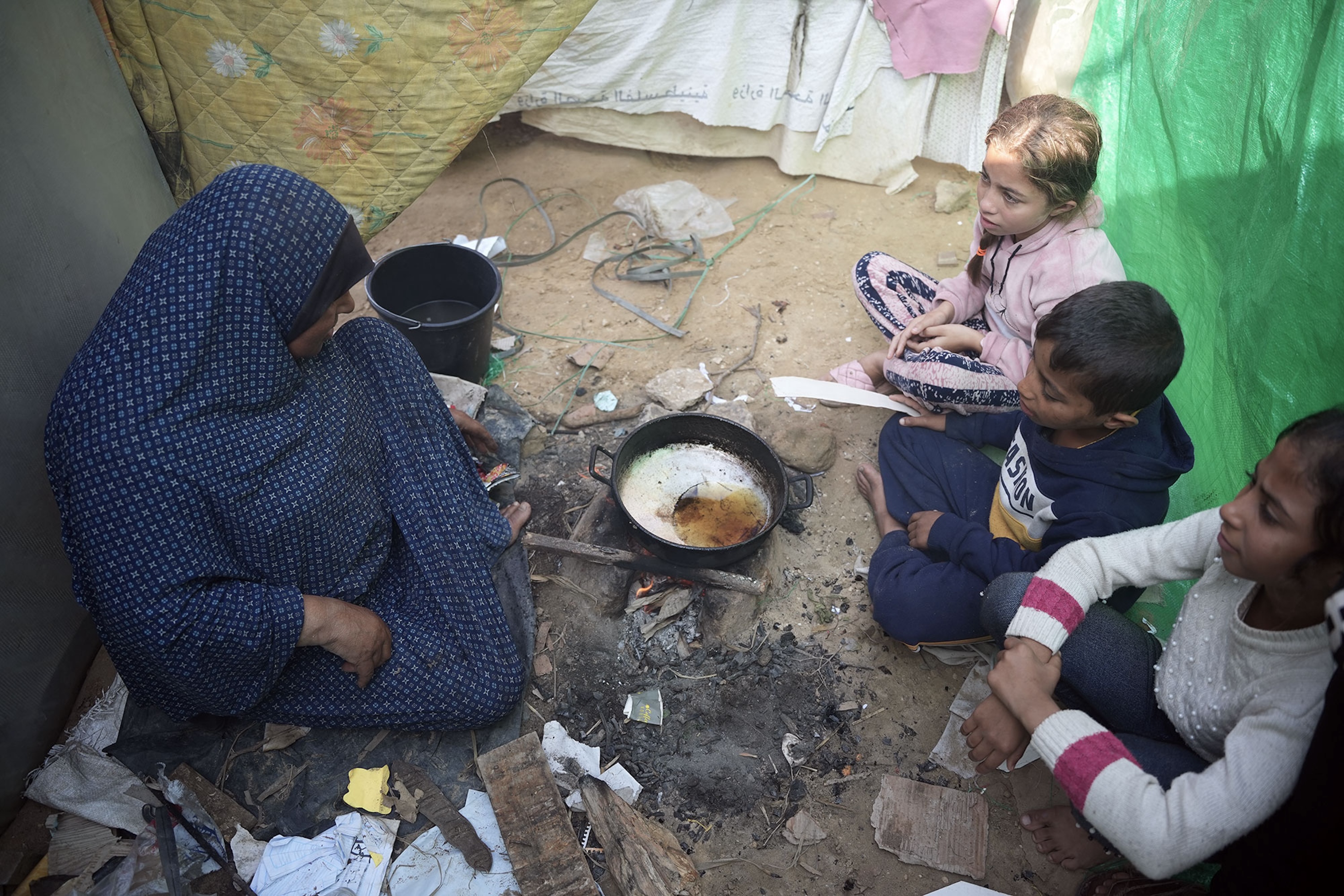 عائلة تقوم بإعداد الطعام في سكن مؤقت في مستشفى شهداء الأقصى.