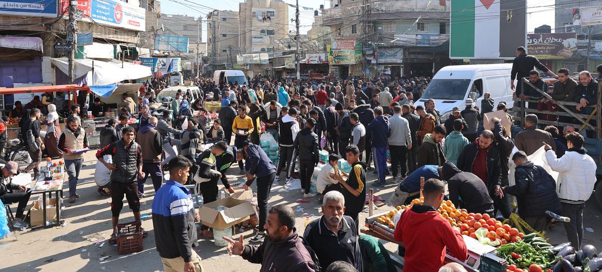 Pessoas deslocadas compram alimentos na Praça Al-Awda, no centro de Rafah, Gaza