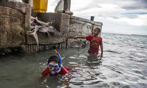 Children play on a jetty on Fale Island in the Pacific Ocean archipelago of Tokelau.