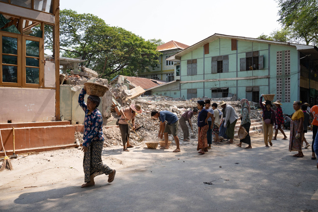 People in Mandalay, Myanmar, remove debris following the earthquake in March 2025.