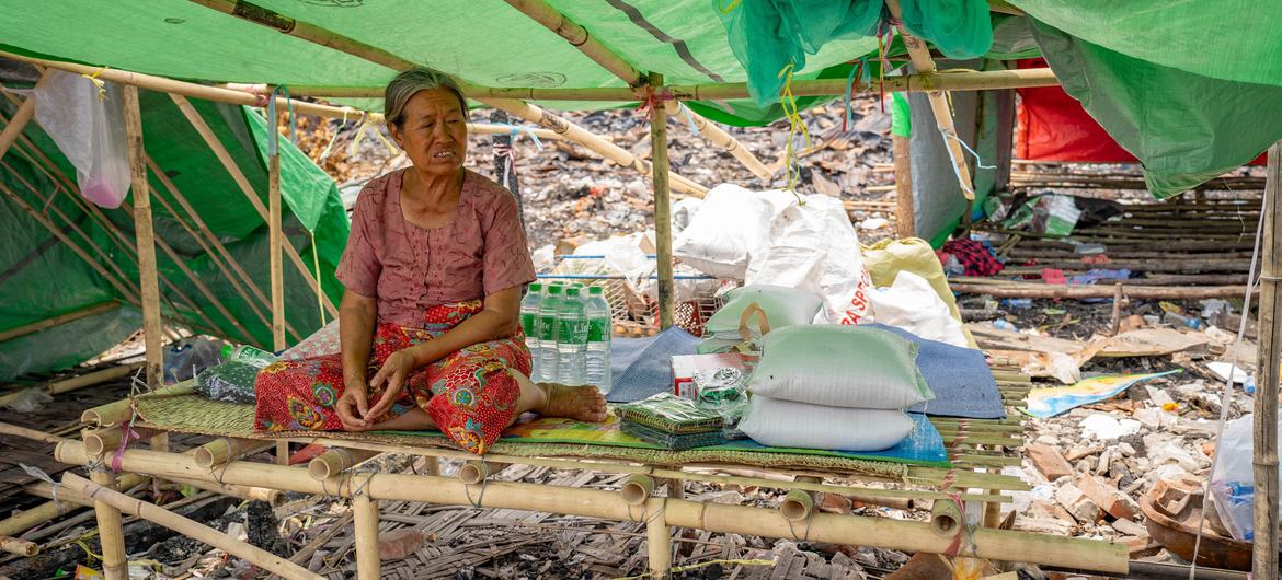 A woman who was affected by the earthquake in Myanmar sits alongside aid items. A woman who was affected by the earthquake in Myanmar sits alongside aid items.