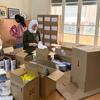 نساء يعبّأن أدوات النظافة في صناديق من الورق المقوى للنساء والفتيات النازحات في لبنان، وهي مبادرة من هيئة الأمم المتحدة للمرأة ومنظمة أسابيل غير الحكومية.