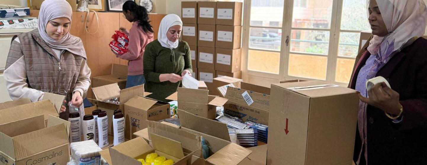 Des femmes emballent des kits d'hygiène dans des boîtes en carton pour les femmes et les filles déplacées au Liban, une initiative menée par ONU Femmes et l'ONG Assabil.