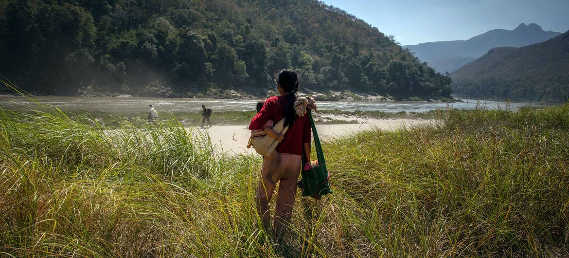 在缅甸东部克伦邦，一个妇女抱着她一岁的女儿徒步一周，逃到与泰国接壤的边境。