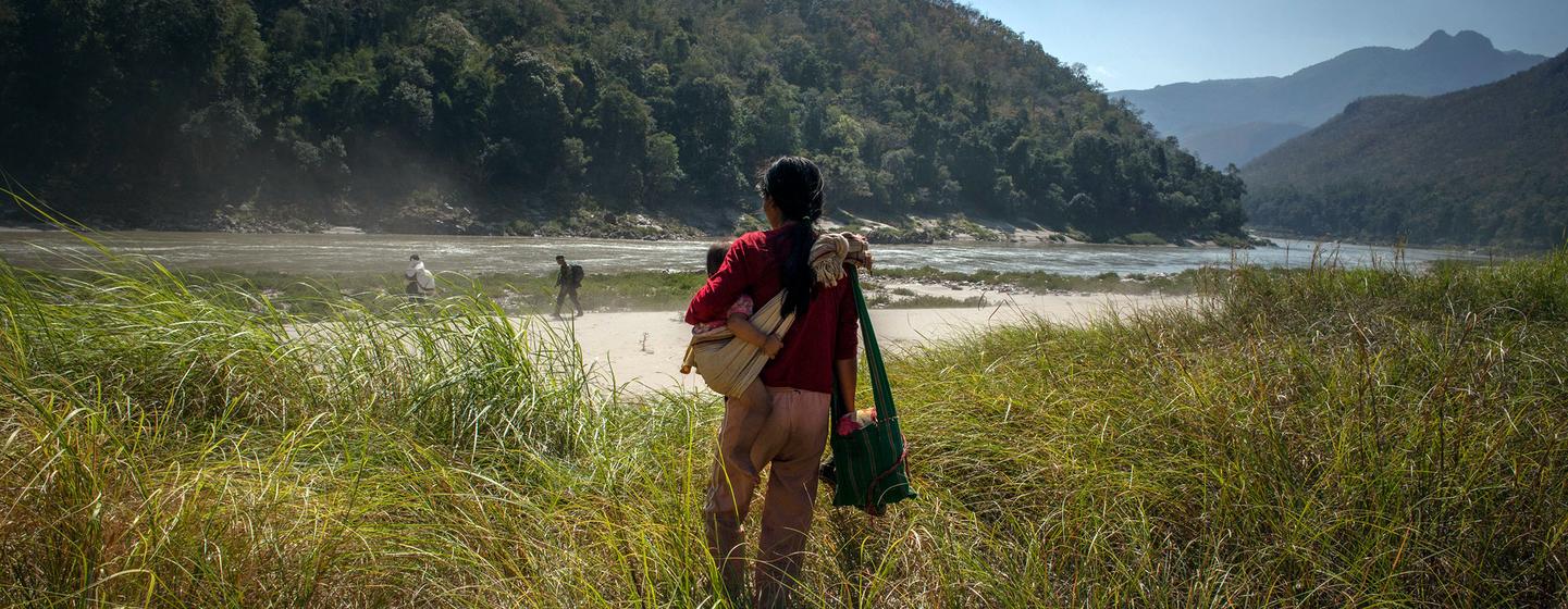 Une femme tient sa fille d'un an dans ses bras alors qu'elle fuit le Myanmar vers la frontière avec la Thaïlande (photo d'archives).