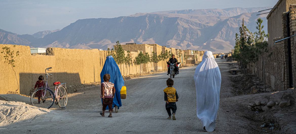 Women and children who were displaced by conflict walk through a village in northern Afghanistan.