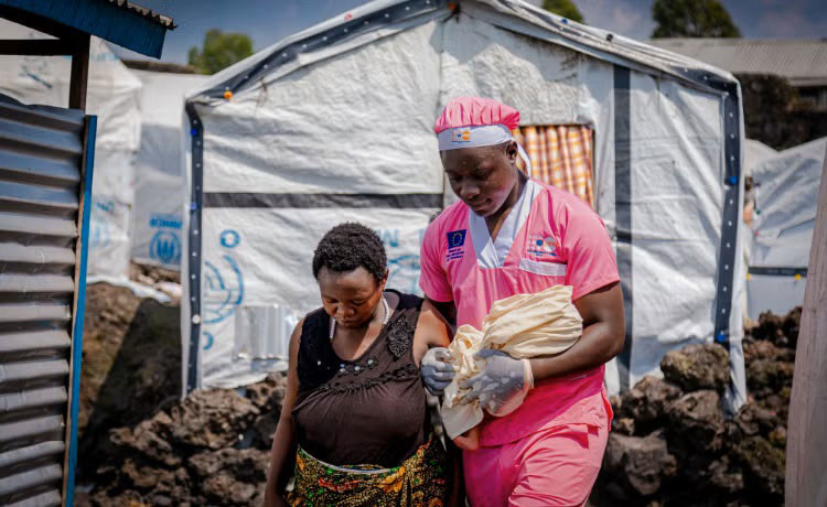Midwife Loti Kubuya Mielor assists a newly arrived displaced woman who gave birth in a shelter in Goma, DR Congo. Midwife Loti Kubuya Mielor assists a newly arrived displaced woman who gave birth in a shelter in Goma, DR Congo.