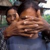 Мать прикрывает лицо своей дочери, которая стала жертвой торговли людьми в возрасте шестнадцати лет 