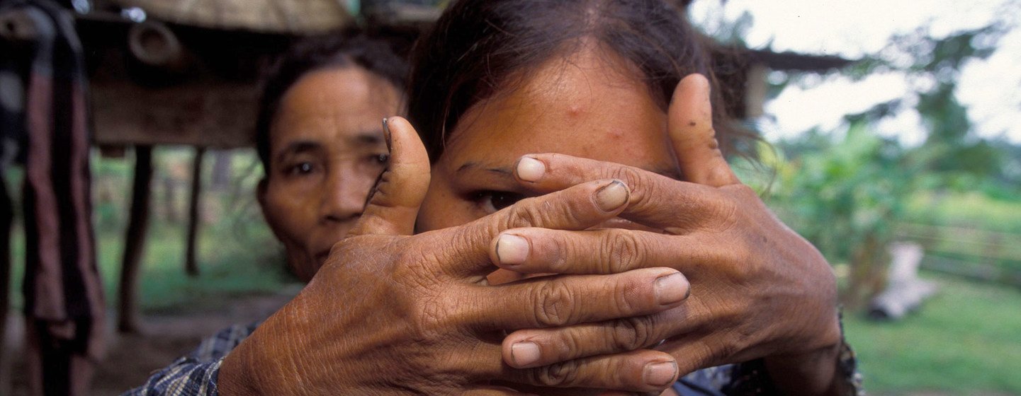 Una madre cubre el rostro de su hija, víctima de la trata a los dieciséis años, para proteger su identidad.
