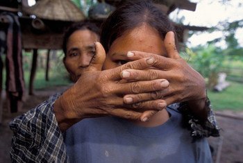 一位母亲遮住了女儿的脸，以保护她的身份。女儿在 16 岁时被拐卖。