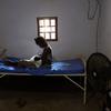 Une jeune mère est assise sur un lit dans un centre de santé de Bangui, en République centrafricaine, et allaite son nouveau-né.