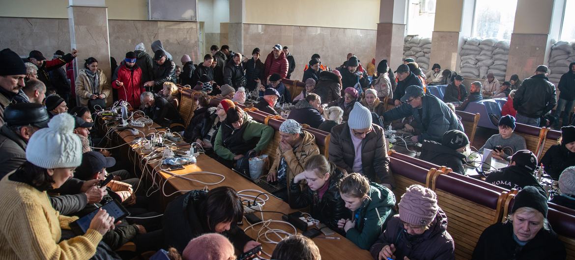 أناس يشجنون هواتفهم المحمولة ويستخدمون شبكة wifi في محطة القطار في خيرسون، أوكرانيا.