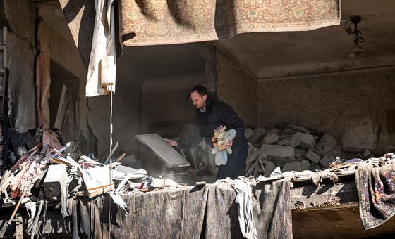 Moradores voltam a prédio atingido por um míssil para recolher seus pertences