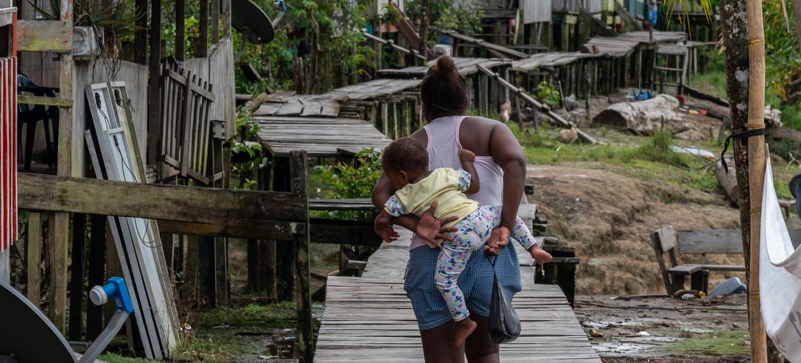 Una madre camina con su bebé en la comunidad Litoral del San Juan, Colombia.