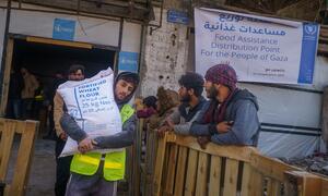 A man carrying a sack of fortified wheat flour at a WFP food distribution point in Beit Lahia, northern Gaza.