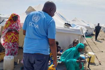 联合国人道主义工作人员与苏丹达尔富尔的境内流离失所者在一起。