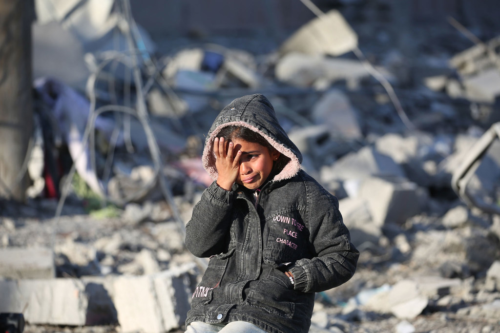 A girl stands amidst the rubble of her destroyed home in Rafah, Gaza.