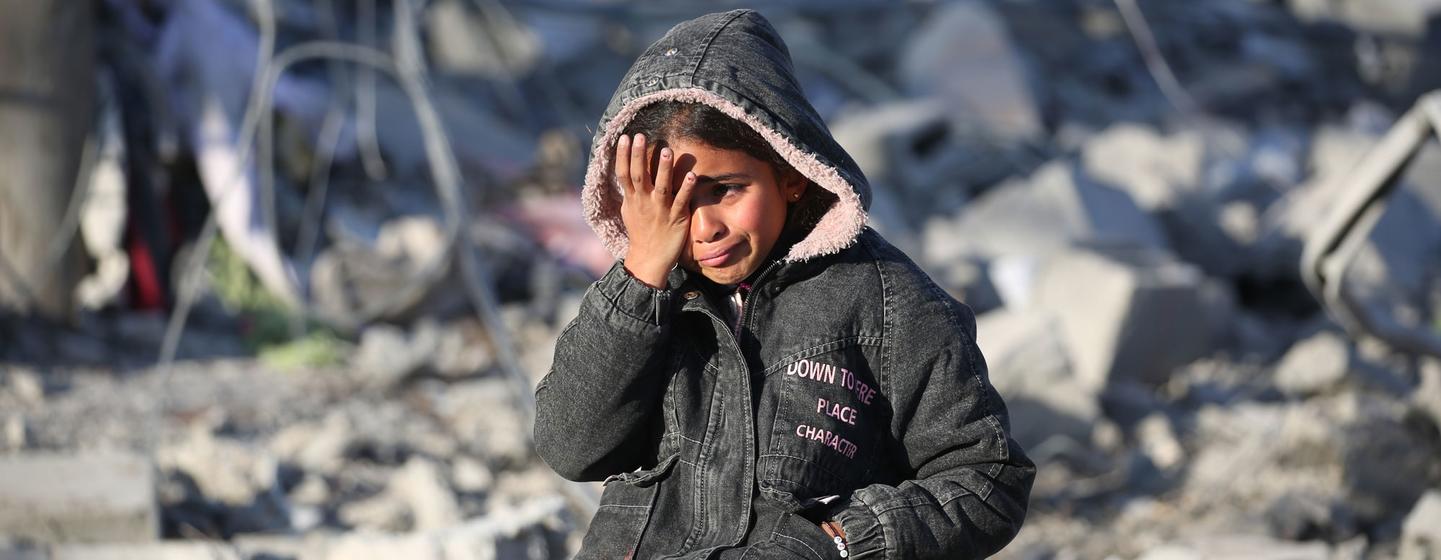 Une jeune Palestinienne est assise dans les décombres d'un immeuble détruit à Gaza, essuyant ses larmes.