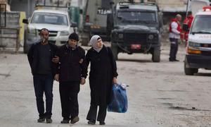 Three people walk through the streets of Jenin in the West Bank.