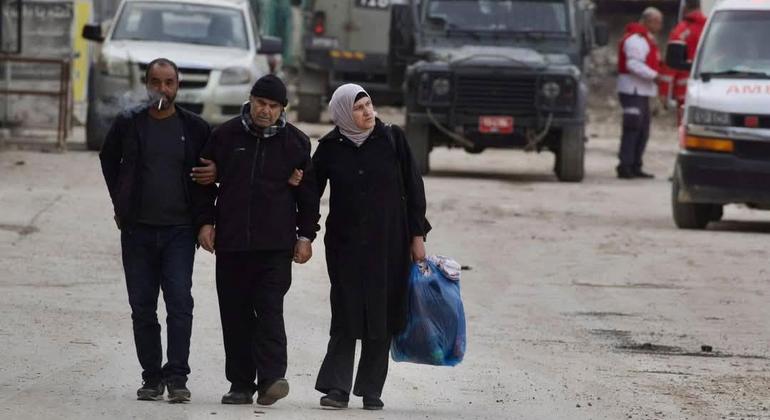 Tres personas caminan por las calles de Yenín, en Cisjordania.