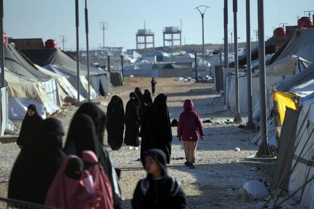 Women and children walk through the Al Hol Camp in Syria, a displacement site housing over 30,000 people.
