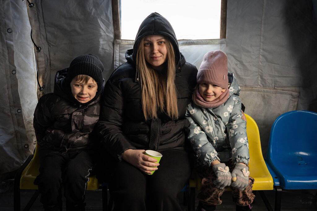 卡特琳娜和她的两个孩子在一个加热点上加热,