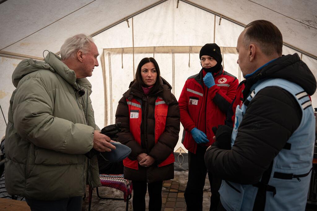 منسق الأمم المتحدة للشؤون الإنسانية في أوكرانيا ماتياس شمالي (ليسار) يلتقي موظفي الصليب الأحمر الأوكراني ومتطوعين.