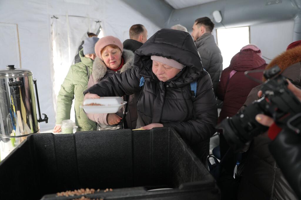 In Boryspil, Ukraine, on 14 January 2026, humanitarian workers and local authorities distribute food to vulnerable people enduring extreme winter conditions with temperatures below -10&deg;C.
