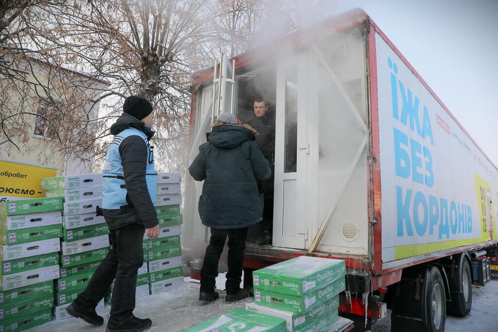 Les travailleurs humanitaires et les autorités locales distribuent des fournitures alimentaires à partir d'un camion à Boryspil, en Ukraine, dans des conditions d'hiver extrêmes avec des températures inférieures à -10°C.